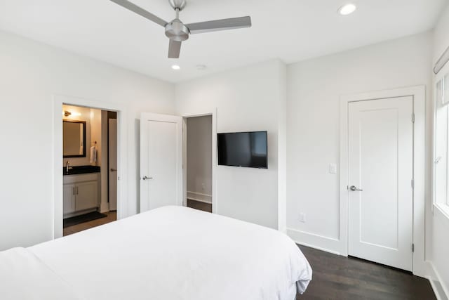 bedroom with a sink, ensuite bathroom, recessed lighting, and dark wood-type flooring