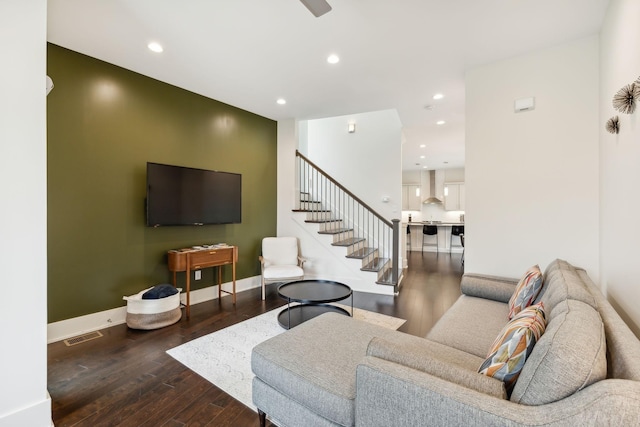 living area with recessed lighting, baseboards, wood finished floors, and stairway