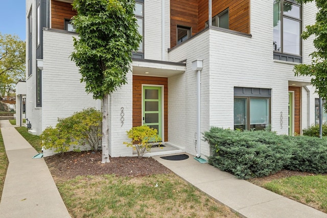property entrance featuring brick siding