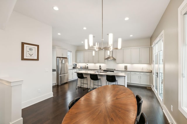 dining room with recessed lighting, dark wood finished floors, baseboards, and a chandelier