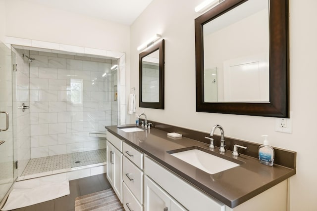 full bath featuring a sink, a shower stall, and double vanity