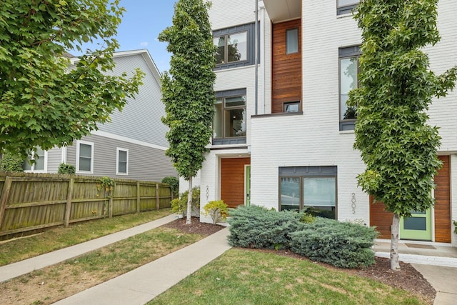 view of front of house featuring a front lawn and fence