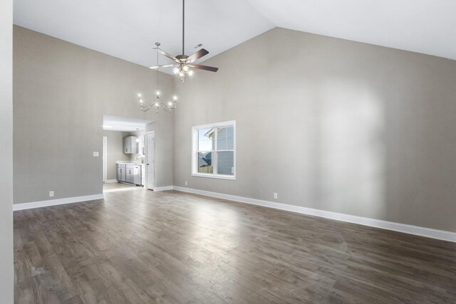 interior space featuring baseboards, dark wood-style flooring, ceiling fan with notable chandelier, and high vaulted ceiling