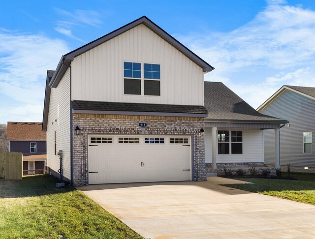 view of front facade featuring board and batten siding, a front yard, concrete driveway, an attached garage, and a shingled roof