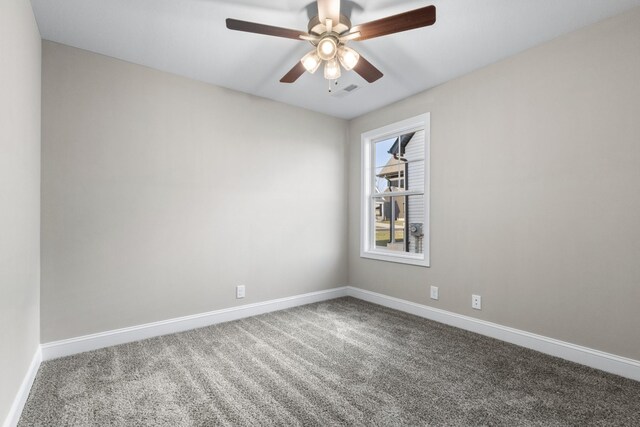 carpeted empty room featuring baseboards, a ceiling fan, and visible vents