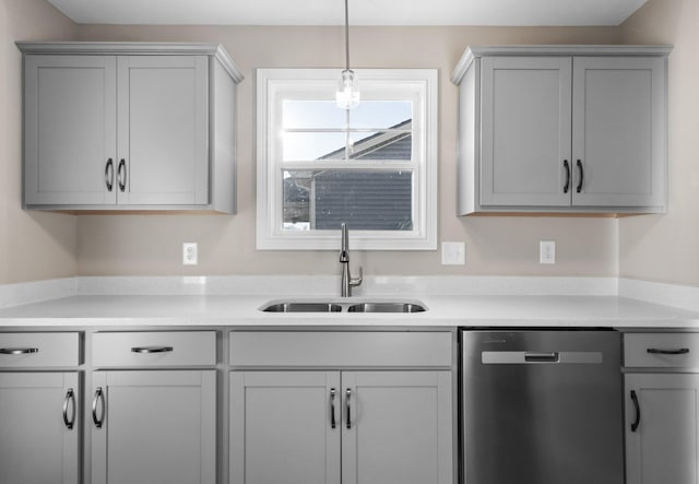 kitchen featuring a sink, light countertops, gray cabinetry, and dishwasher