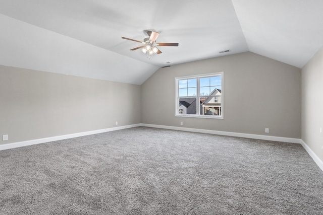 additional living space featuring a ceiling fan, visible vents, carpet floors, baseboards, and lofted ceiling