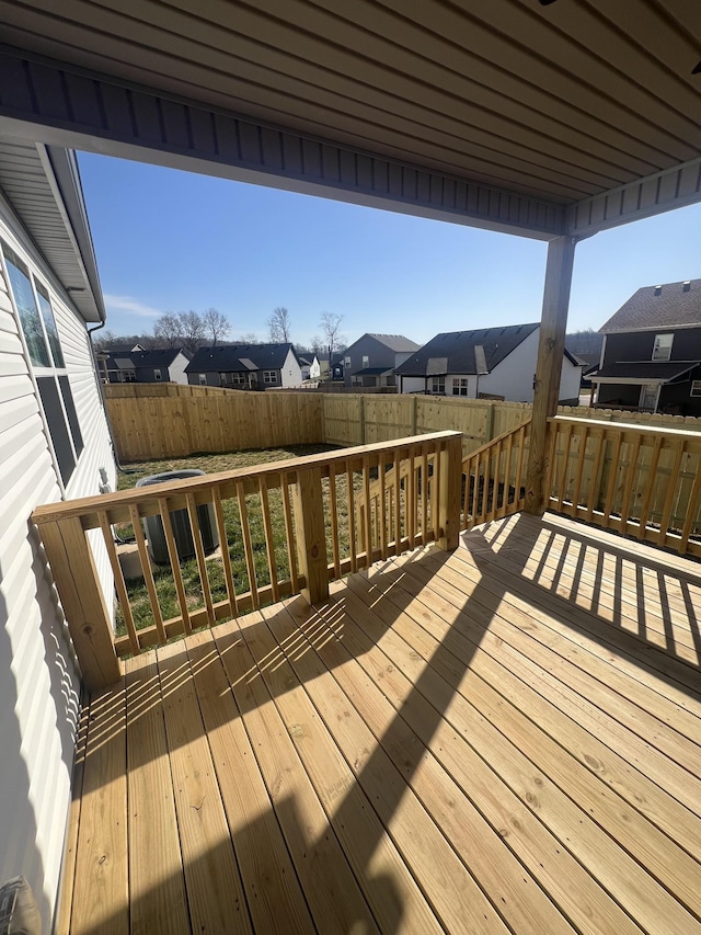 deck with a residential view, cooling unit, and a fenced backyard
