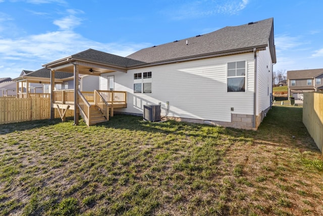 back of house with ceiling fan, a deck, a fenced backyard, central AC unit, and a yard