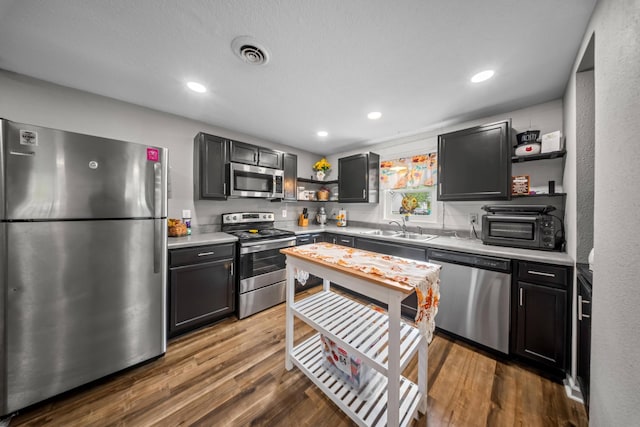 kitchen featuring a sink, light countertops, open shelves, and stainless steel appliances