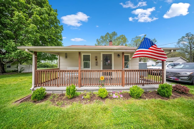 single story home with a chimney, a porch, and a front lawn