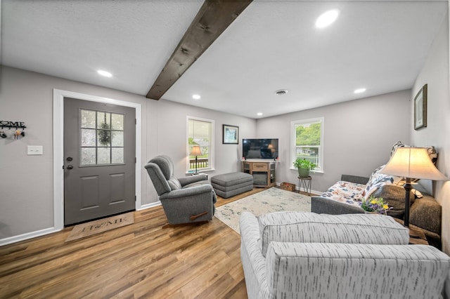 living area featuring baseboards, beamed ceiling, recessed lighting, and wood finished floors