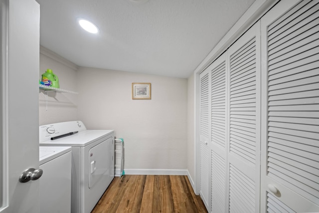 laundry area featuring baseboards, laundry area, washing machine and dryer, and wood finished floors