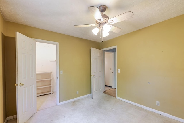 unfurnished bedroom with baseboards, light carpet, and a ceiling fan