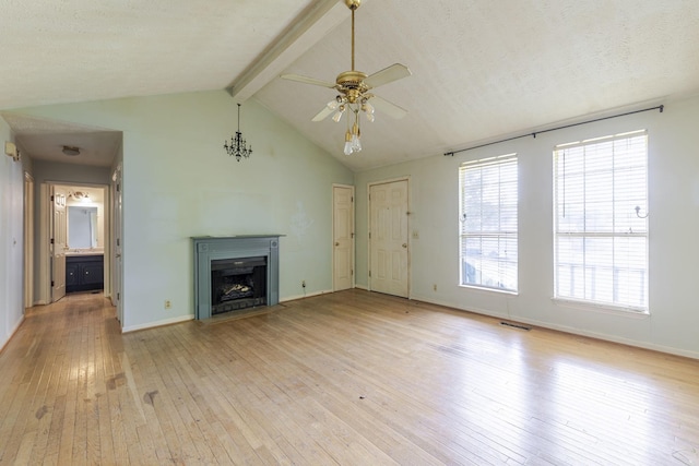 unfurnished living room with visible vents, ceiling fan, vaulted ceiling with beams, a fireplace with flush hearth, and light wood finished floors