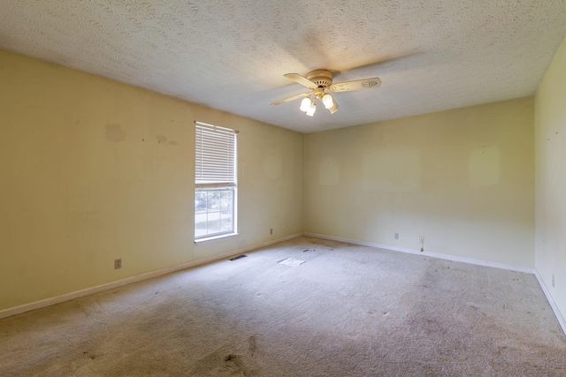 carpeted empty room with a textured ceiling, ceiling fan, and baseboards