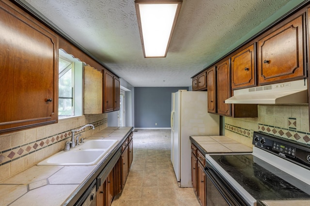 kitchen with tile counters, under cabinet range hood, and electric stove