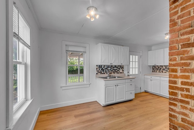 kitchen with plenty of natural light, decorative backsplash, white cabinets, and light countertops