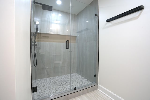 full bath with baseboards and a shower stall