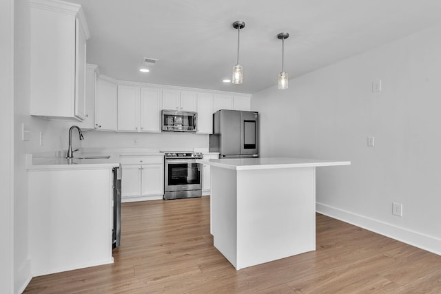 kitchen featuring appliances with stainless steel finishes, a sink, light countertops, white cabinets, and light wood-style flooring