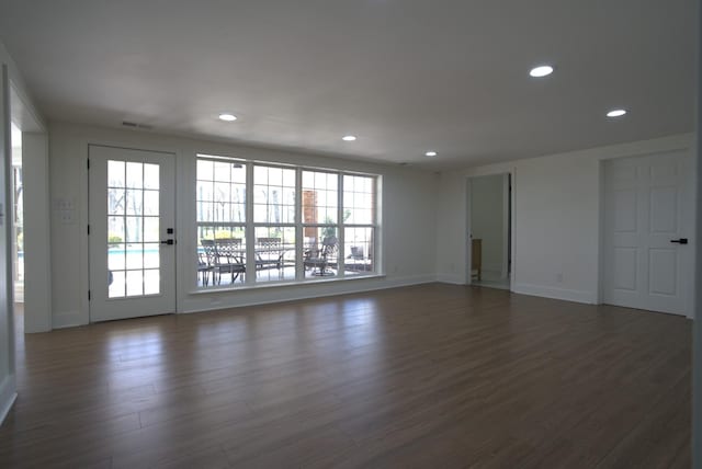 unfurnished living room featuring baseboards, visible vents, recessed lighting, and dark wood-type flooring