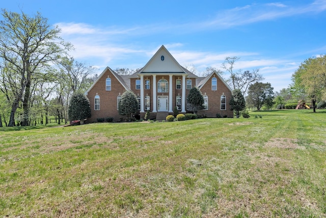 neoclassical home with brick siding and a front lawn