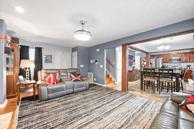 2764 Ann Dr, Clarksville, TN 37040 - living room with a textured ceiling, visible vents, stairway, baseboards, and a chandelier