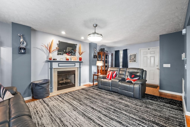 2764 Ann Dr, Clarksville, TN 37040 - living room with a textured ceiling, a tile fireplace, wood finished floors, baseboards, and recessed lighting