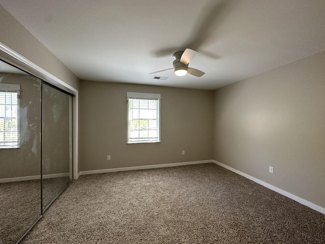 unfurnished bedroom featuring ceiling fan, carpet, baseboards, visible vents, and a closet