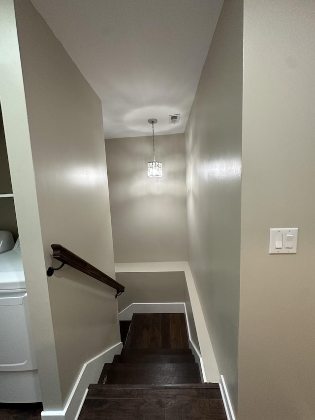 staircase with visible vents, baseboards, and wood finished floors