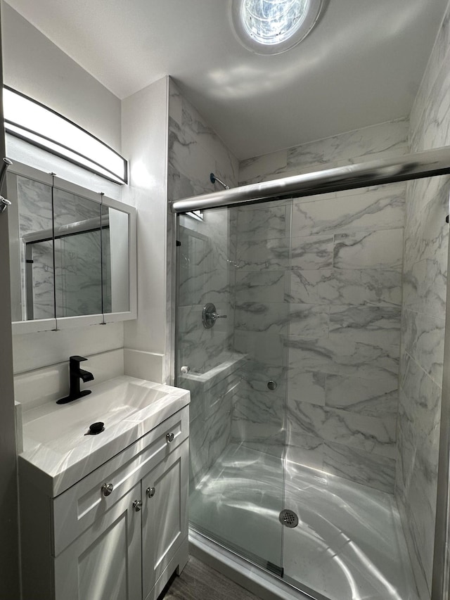 bathroom with a marble finish shower and vanity