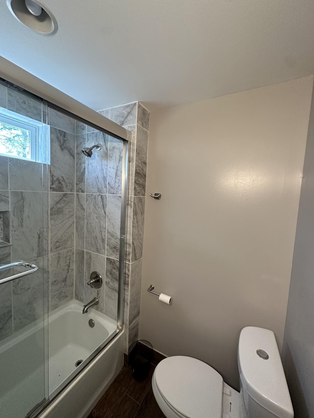 bathroom with toilet, combined bath / shower with glass door, and wood finished floors