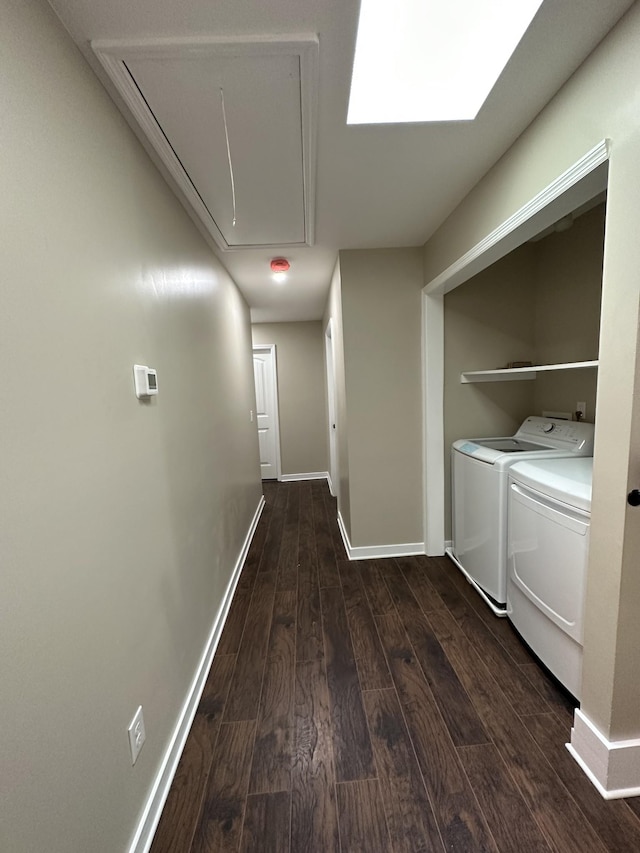hall featuring baseboards, attic access, dark wood-style flooring, and washer and clothes dryer