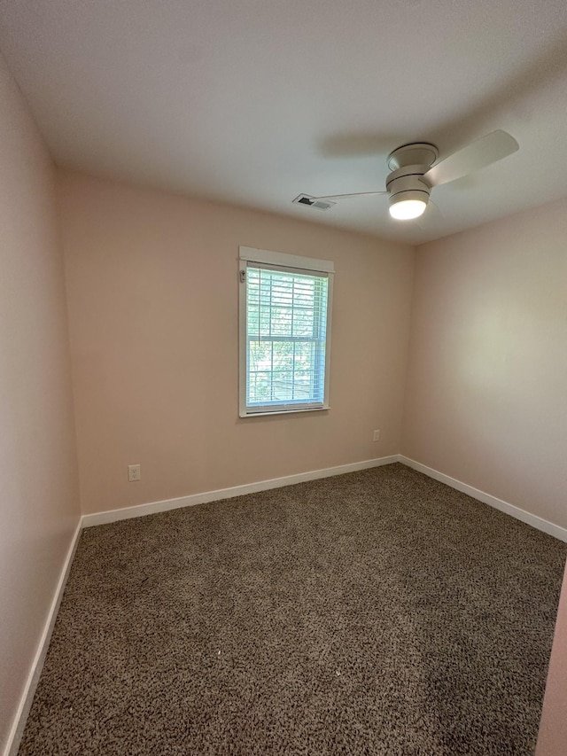 unfurnished room with visible vents, carpet flooring, baseboards, and a ceiling fan