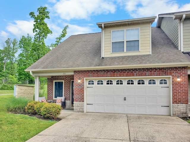 view of front of property with a shingled roof, concrete driveway, and brick siding
