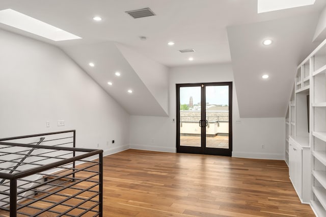 additional living space featuring baseboards, light wood finished floors, visible vents, and french doors