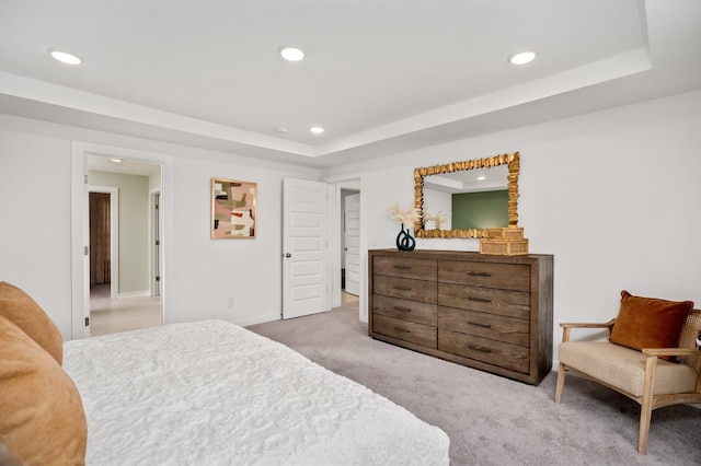 carpeted bedroom with a raised ceiling and recessed lighting