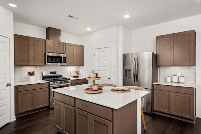 kitchen with light countertops, stainless steel appliances, and dark wood finished floors