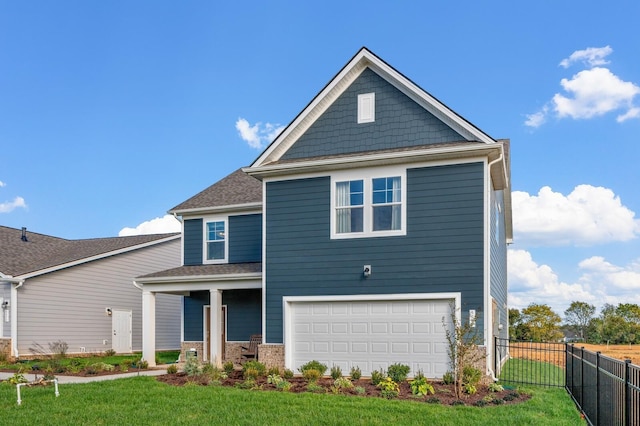 view of front of house with an attached garage, fence, and a front lawn
