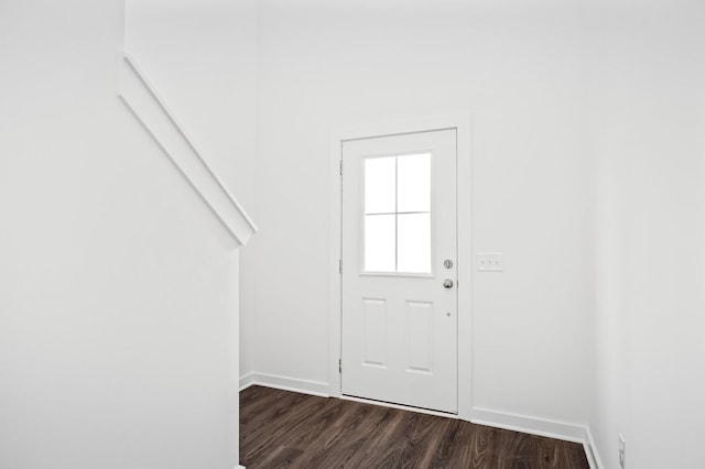 doorway featuring baseboards and dark wood-type flooring