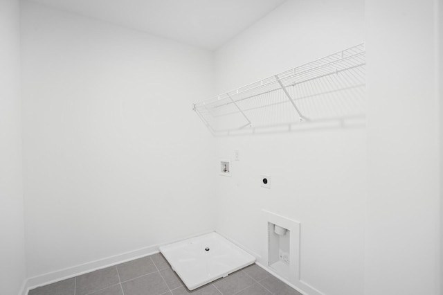 laundry room featuring laundry area, baseboards, hookup for a washing machine, dark tile patterned floors, and electric dryer hookup