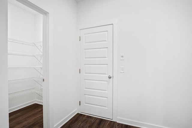 hall with baseboards and dark wood finished floors