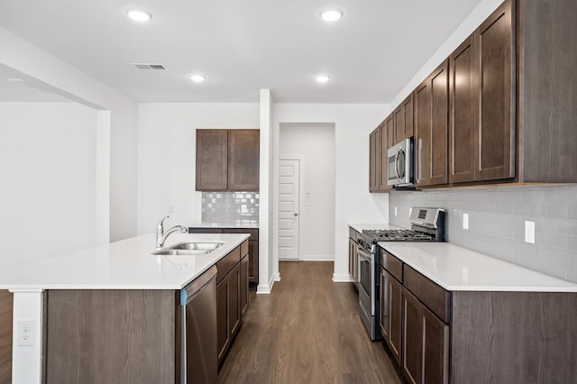 kitchen featuring dark wood-style flooring, a sink, light countertops, stainless steel appliances, and visible vents