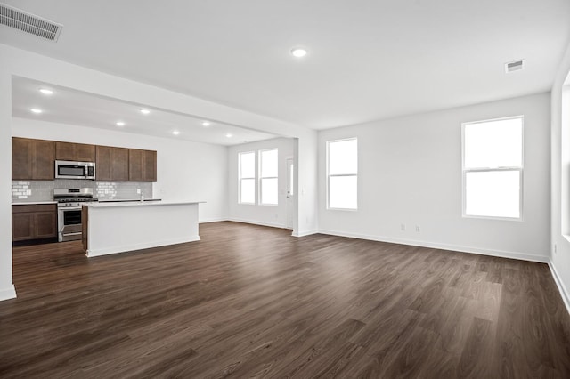 unfurnished living room featuring recessed lighting, baseboards, visible vents, and dark wood-type flooring
