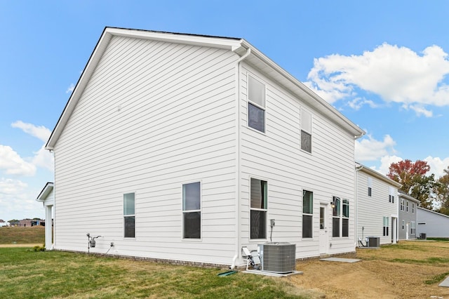 rear view of property with a yard and cooling unit