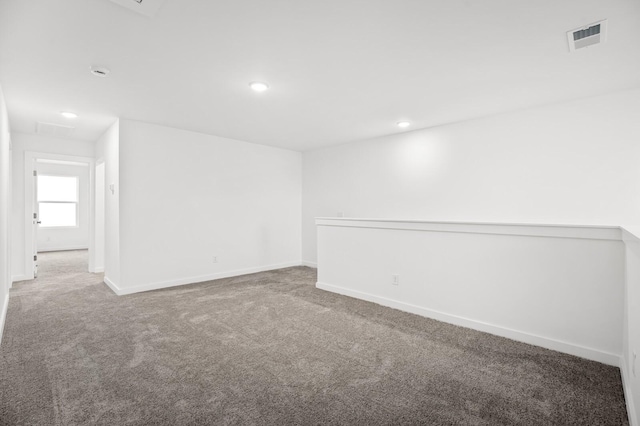 spare room with carpet flooring, recessed lighting, baseboards, and visible vents