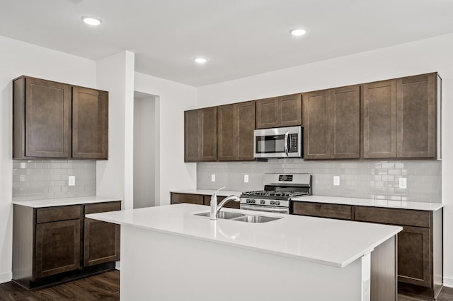 kitchen featuring backsplash, dark brown cabinets, light countertops, stainless steel appliances, and dark wood-type flooring