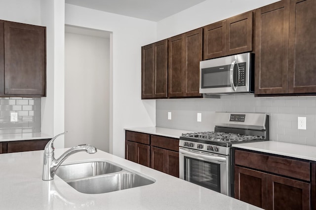 kitchen with a sink, light countertops, backsplash, and stainless steel appliances