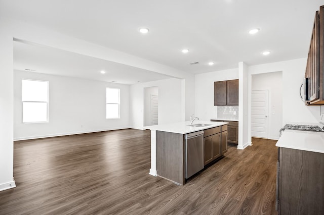 kitchen featuring a sink, appliances with stainless steel finishes, dark wood finished floors, and light countertops