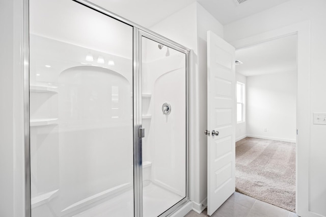 full bathroom with tile patterned floors, a shower stall, and baseboards